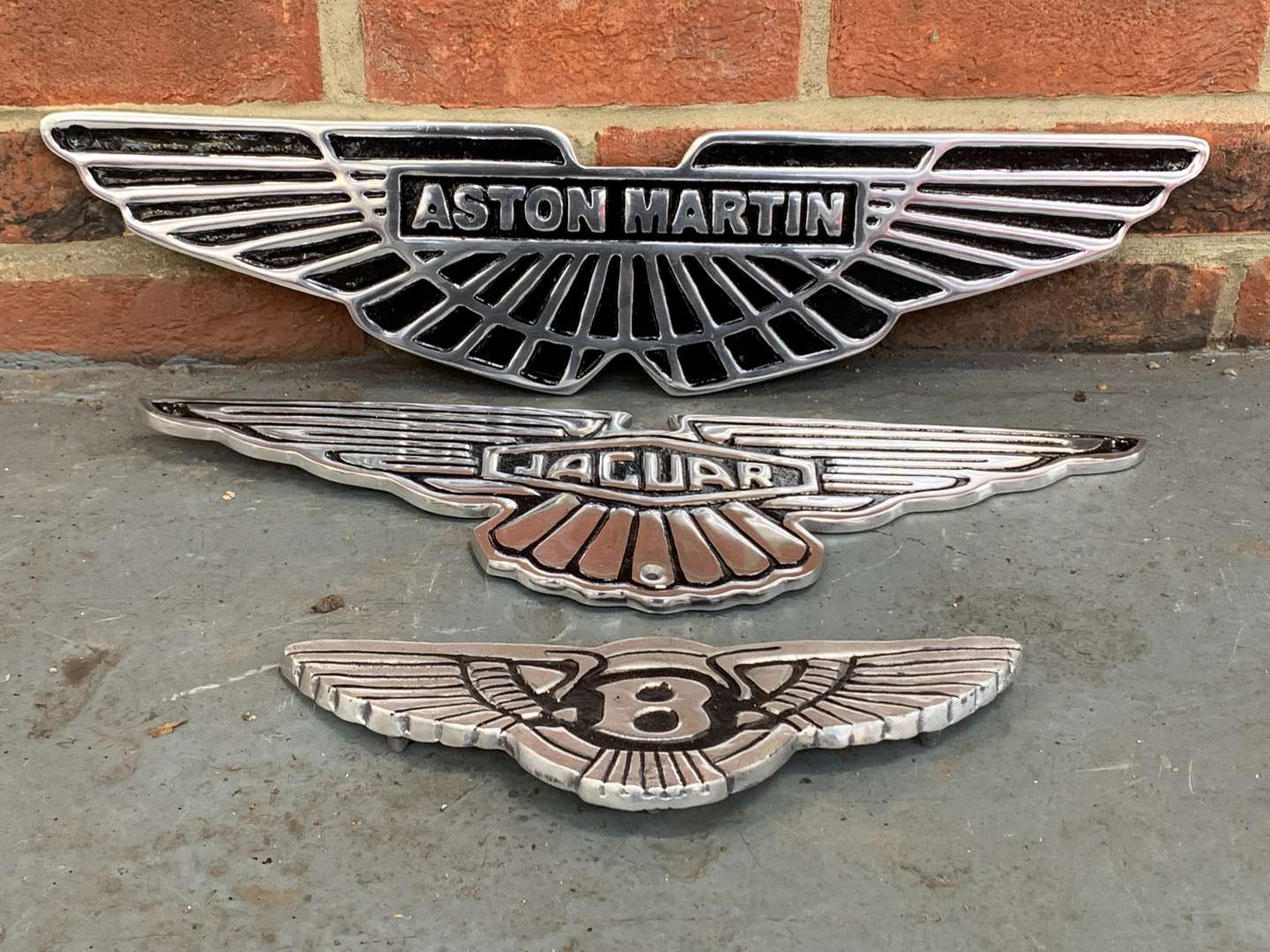 <p>Three Cast Aluminum Aston Martin/Bentley/Jaguar Emblem Signs</p>